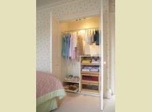 Built in painted and illuminated wardrobe with slide-out shelving and shoe trays